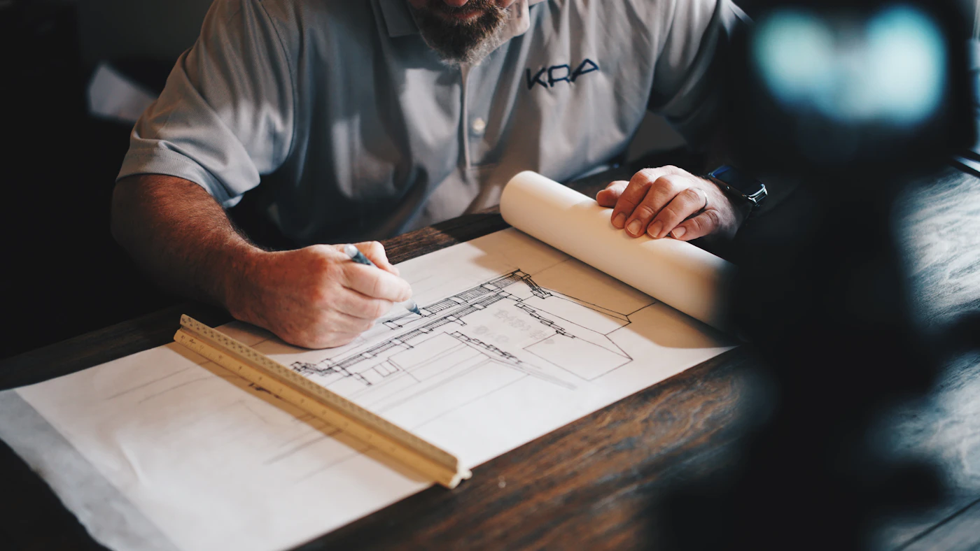 Designer hand-drafting architectural interior plans during a consultation
